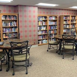 A cozy library reading area with tables and bookshelves filled with books.