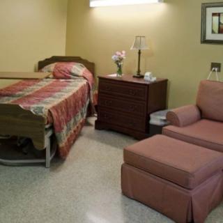 A cozy room with a single bed and an armchair.