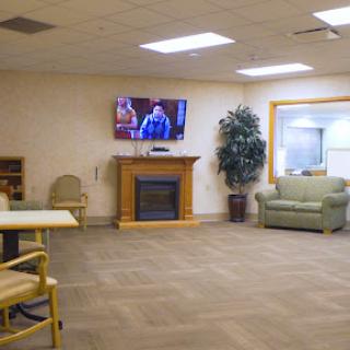 A cozy lounge area featuring comfortable seating, a television, and a fireplace.