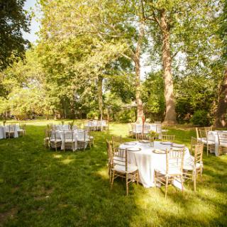 A beautifully set outdoor venue for a celebration, surrounded by lush greenery.