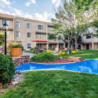 A serene view of an apartment complex with well-maintained gardens and lush greenery.