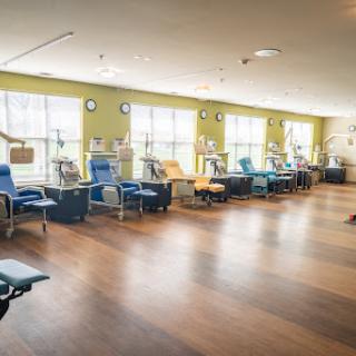 A spacious and well-lit blood donation center featuring comfortable chairs for donors.