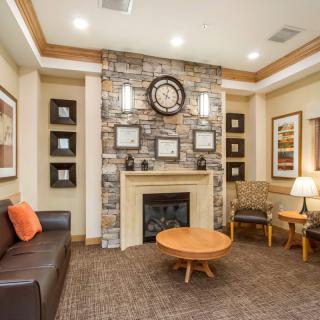 A cozy living room featuring a stone fireplace, comfortable seating, and warm lighting.