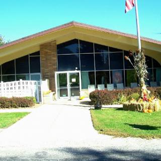 A modern architectural building with large windows and an American flag in front.
