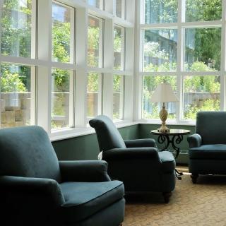 A cozy living room with armchairs and large windows letting in natural light.