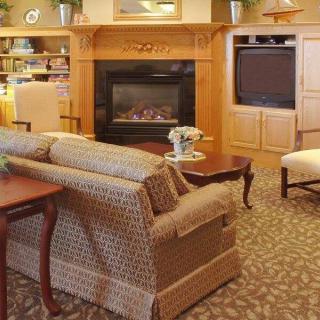 A cozy living room with a fireplace, sofa, and television.