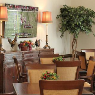 A cozy dining area with wooden furniture, decorative plants, and warm lighting.