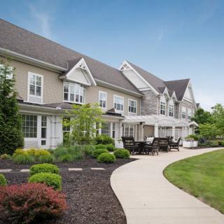 A modern residential building with a well-maintained garden and a winding pathway.
