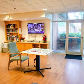 A cozy interior space featuring a chair, table, and a television, perfect for relaxation or social gatherings.