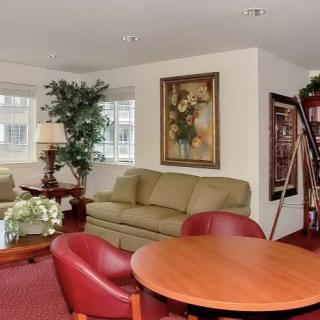 A cozy living room with comfortable seating, artwork, and a decorative plant.
