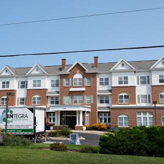 A large residential building with a mix of brick and white siding.