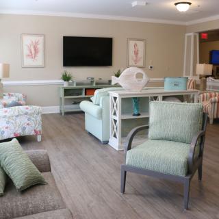 A cozy and modern living room featuring comfortable seating, a large TV, and decorative elements.