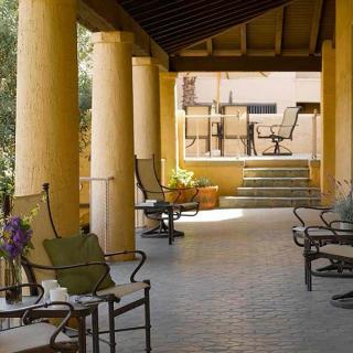 A peaceful outdoor patio area with seating and columns, offering a cozy spot for relaxation.
