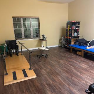 A spacious therapy room equipped for rehabilitation with exercise tools and a treatment table.