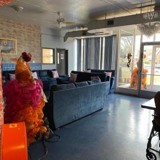 A brightly decorated interior lounge area featuring colorful costumes and modern furniture.