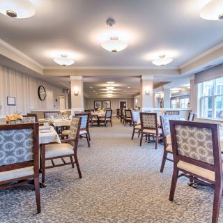A spacious and elegantly designed dining area with neatly arranged tables and chairs.