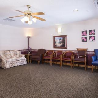 A quiet waiting room with various seating options and a ceiling fan.