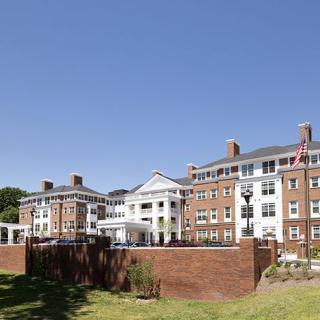 A large, historic brick building under a clear blue sky.