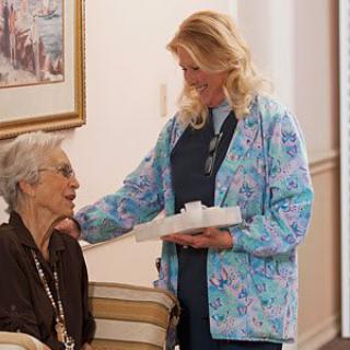 A caregiver tending to an elderly woman at home.