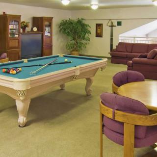 A cozy game room featuring a pool table, comfortable seating, and entertainment options.