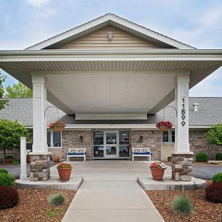 A welcoming entrance to a building with an awning and potted plants.