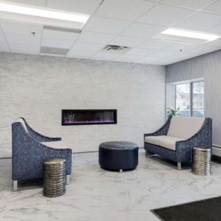 A modern lobby with comfortable seating and a sleek fireplace.
