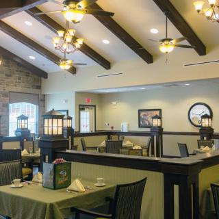 A cozy restaurant interior with wooden ceiling beams and elegant chandeliers.