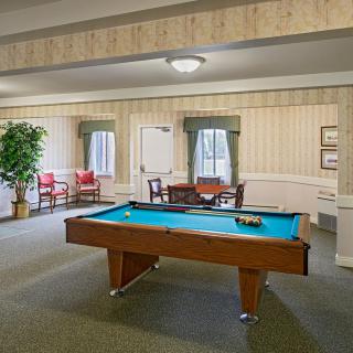 A cozy recreation room featuring a pool table and comfortable seating area.