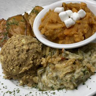 A delightful plate of soul food featuring stuffing, sweet potato mash with marshmallows, and crispy fried green tomatoes.