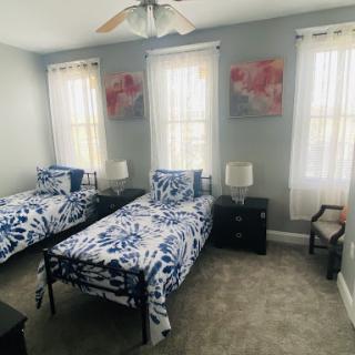 A cozy and bright bedroom featuring twin beds with floral bedding and soft natural light.