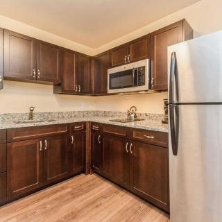 A modern kitchen with dark wood cabinets and stainless steel appliances.