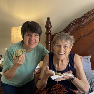 A joyful moment shared between two women, enjoying a delightful treat together.