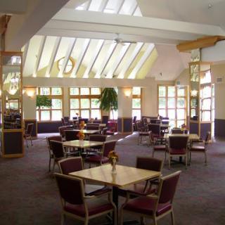 A spacious and well-lit dining area featuring modern furniture and a welcoming ambiance.