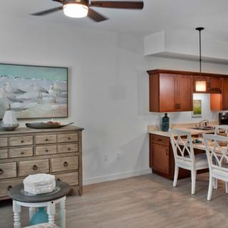 A cozy dining area with wooden cabinets, a ceiling fan, and stylish decor.
