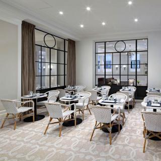 A modern and elegantly designed restaurant dining area with neatly arranged tables and chairs.