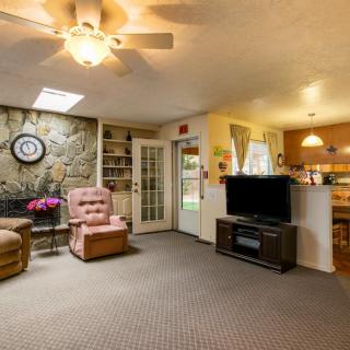 Cozy living room with an armchair, television, and ceiling fan.