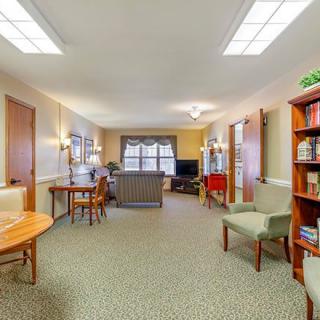 A spacious living room with cozy seating and bookshelves.