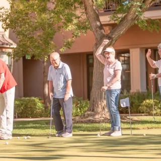 A group of seniors enjoying a game of golf outdoors.