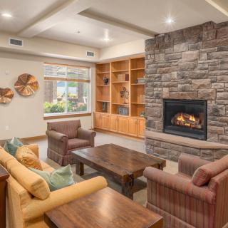 A cozy living room with a fireplace, comfortable seating, and built-in bookshelves.