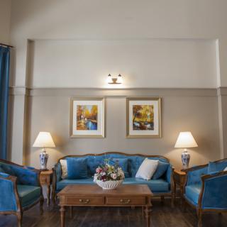 A classic living room setup with blue upholstered furniture and elegant decor.