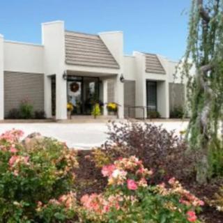 Front view of a modern building with landscaped gardens and flowers.