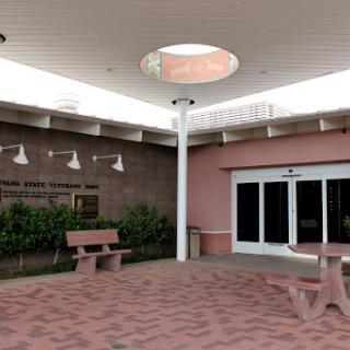 A modern courtyard featuring benches and a skylight, surrounded by landscaped greenery.