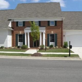 A suburban brick house with a neatly maintained lawn and double garages.