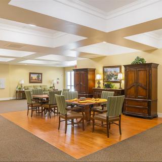 A well-lit dining area with wooden tables and chairs, featuring elegant decor and ample space.