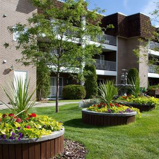 An apartment complex with well-maintained landscaping and flower beds.