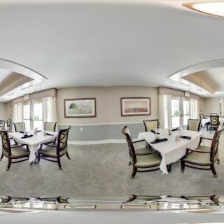 A well-decorated dining room with tables set with white tablecloths.