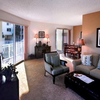 A cozy living room with elegant furniture and a view of the balcony.