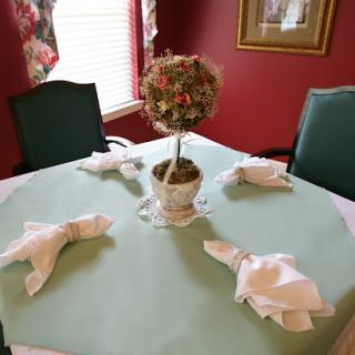 A beautifully arranged dining table featuring a delicate centerpiece and intricately folded napkins.
