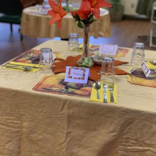 A beautifully set dining table adorned with a floral centerpiece and neatly arranged cutlery.