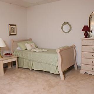 A cozy bedroom with a single bed, dresser, and decorative elements.